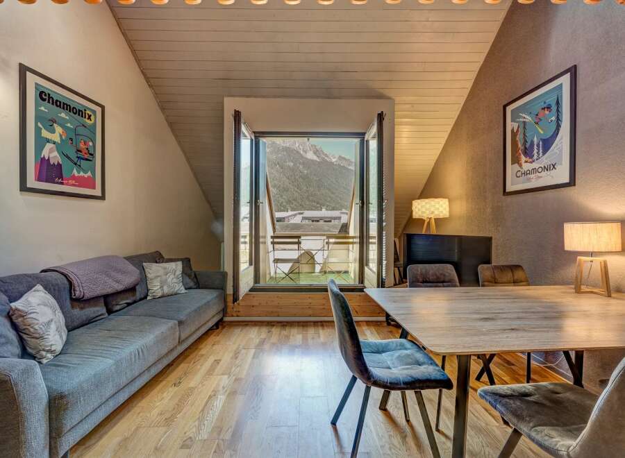 Experience mountain living in this charming apartment featuring a cozy living area with a comfortable sofa and a dining space perfect for intimate meals.