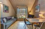 Experience mountain living in this charming apartment featuring a cozy living area with a comfortable sofa and a dining space perfect for intimate meals.