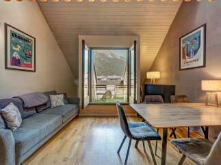 Experience mountain living in this charming apartment featuring a cozy living area with a comfortable sofa and a dining space perfect for intimate meals.