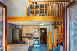 Discover this charming loft apartment featuring a modern kitchen with light wood cabinetry and stone backsplash, perfect for preparing meals.