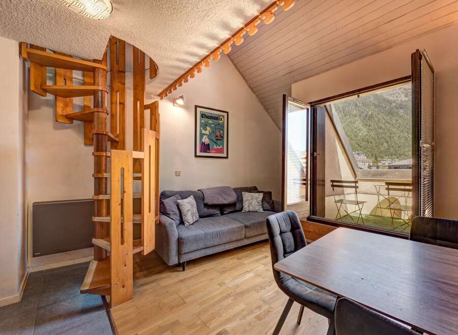 Discover this charming apartment featuring a unique spiral wooden staircase leading to the upper level.