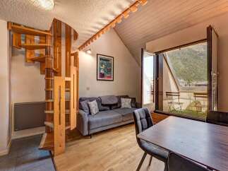 Discover this charming apartment featuring a unique spiral wooden staircase leading to the upper level.