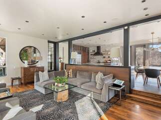 Experience modern living in this open-concept home, featuring a spacious sectional sofa and a stylish coffee table perfect for gatherings.