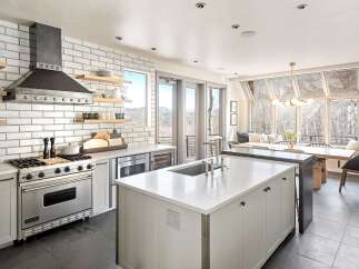 Experience luxury mountain living in this stunning kitchen, featuring a professional-grade Viking range and a sleek, modern range hood.