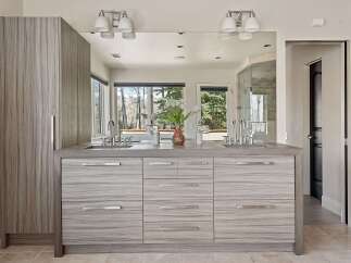 This modern bathroom features a sleek double vanity with a stone countertop and ample storage.