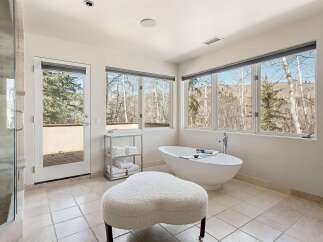 Experience ultimate relaxation in this luxurious bathroom featuring a stunning freestanding soaking tub with breathtaking mountain views.