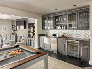 Experience ultimate entertainment in this luxurious game room, featuring a professional pool table and a fully equipped bar with a wine fridge and ample glassware.