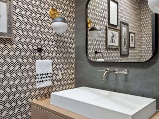This modern powder room features a striking geometric wallpaper that adds a bold statement to the space.
