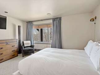 Experience comfort and style in this inviting bedroom, featuring a plush king-sized bed dressed in crisp white linens.