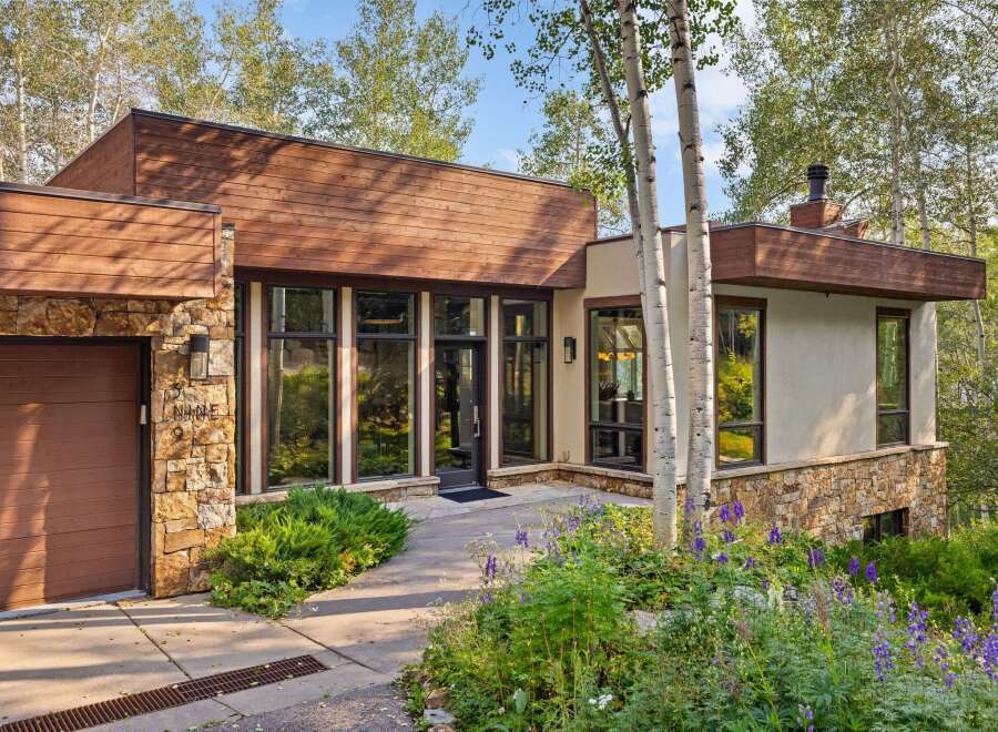 Discover modern mountain living in this stunning home, featuring a striking blend of natural stone and warm wood siding.