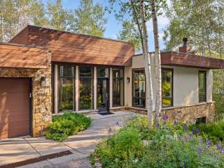 Discover modern mountain living in this stunning home, featuring a striking blend of natural stone and warm wood siding.