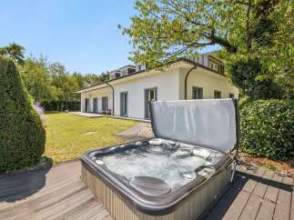 Experience ultimate relaxation in this stunning backyard oasis, featuring a bubbling hot tub perfect for unwinding after a long day.