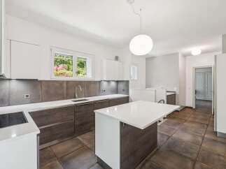This modern kitchen boasts sleek white countertops and dark wood cabinetry, creating a sophisticated and functional space.