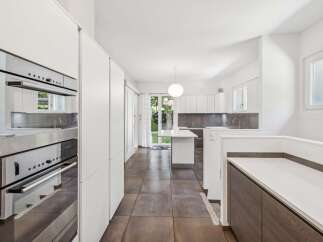 Experience modern living in this stunning kitchen featuring sleek white cabinetry and integrated stainless steel appliances.