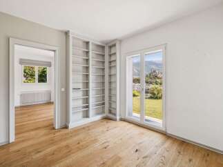 Discover this beautifully appointed room featuring a built-in floor-to-ceiling bookshelf, perfect for a home library or study.