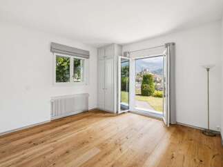 Experience breathtaking views from this bright and airy room, featuring large windows and double doors that open to a stunning landscape.