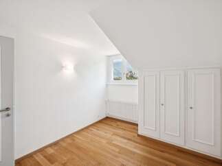 Discover this charming room featuring a sleek white door and a modern wall sconce.