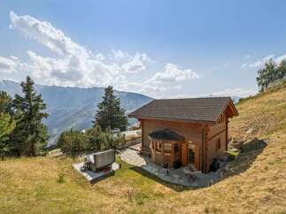 Experience breathtaking mountain views from this charming wooden chalet, perfect for a serene getaway.