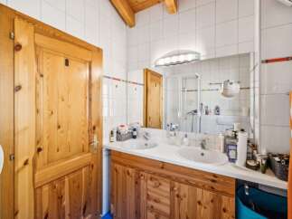 This charming bathroom features a double vanity with ample counter space and storage, perfect for families or couples.