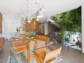Experience modern luxury in this stunning dining area, featuring a sleek glass-top table surrounded by elegant leather chairs.