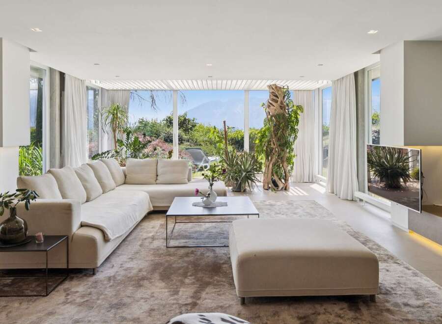 Experience luxurious living in this spacious modern living room, featuring a large sectional sofa and an ottoman perfect for relaxation.
