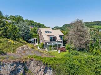 Nestled on a scenic hillside, this modern home offers breathtaking views and a serene living environment.
