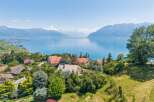 Experience breathtaking panoramic views of a serene lake and majestic mountains from this stunning property.