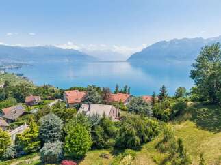 Experience breathtaking panoramic views of a serene lake and majestic mountains from this stunning property.