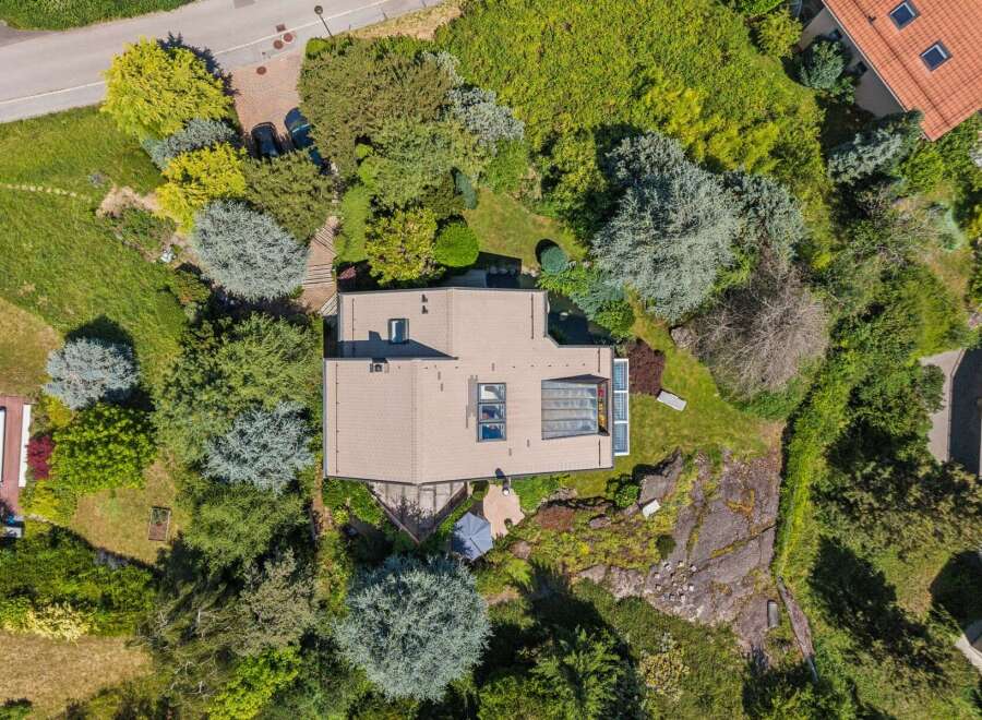 Discover this stunning property from an aerial perspective, showcasing a modern home nestled amidst lush greenery and mature trees.