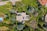 Discover this stunning property from an aerial perspective, showcasing a modern home nestled amidst lush greenery and mature trees.