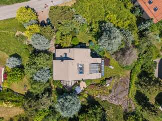 Discover this stunning property from an aerial perspective, showcasing a modern home nestled amidst lush greenery and mature trees.