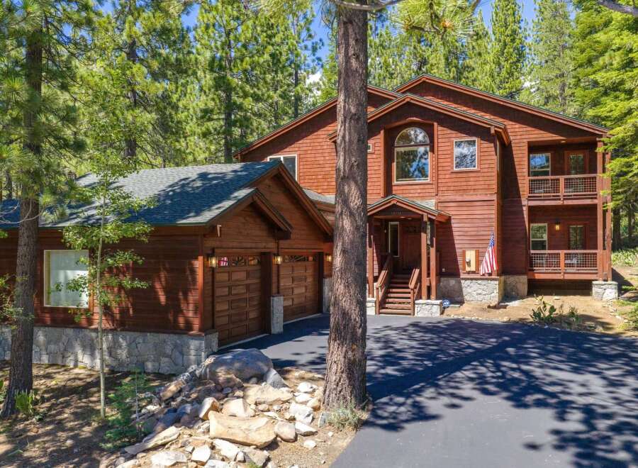 Nestled among tall pine trees, this stunning wooden home offers a serene mountain retreat.