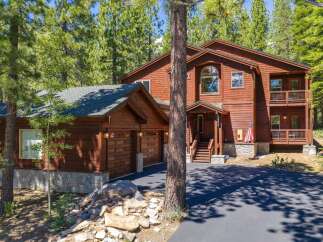 Nestled among tall pine trees, this stunning wooden home offers a serene mountain retreat.