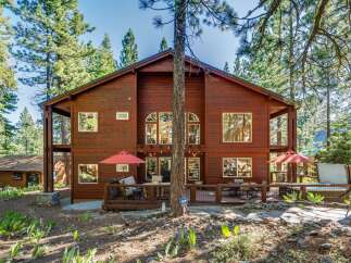 Experience mountain living in this stunning wooden home nestled among tall pine trees.