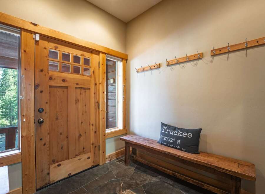 Step into this welcoming entryway featuring a rustic wooden door with glass panes, perfect for letting in natural light.