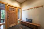 Step into this welcoming entryway featuring a rustic wooden door with glass panes, perfect for letting in natural light.