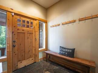 Step into this welcoming entryway featuring a rustic wooden door with glass panes, perfect for letting in natural light.