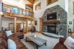 Experience rustic luxury in this stunning living room, featuring a grand stone fireplace as the centerpiece.