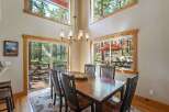 Experience breathtaking forest views from this stunning dining area, featuring a large wooden table perfect for gatherings.