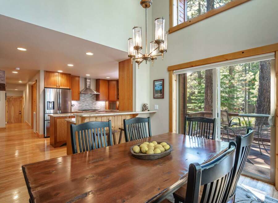Experience rustic charm and modern convenience in this spacious dining area, featuring a large wooden table perfect for gatherings.