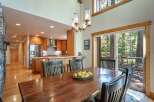 Experience rustic charm and modern convenience in this spacious dining area, featuring a large wooden table perfect for gatherings.