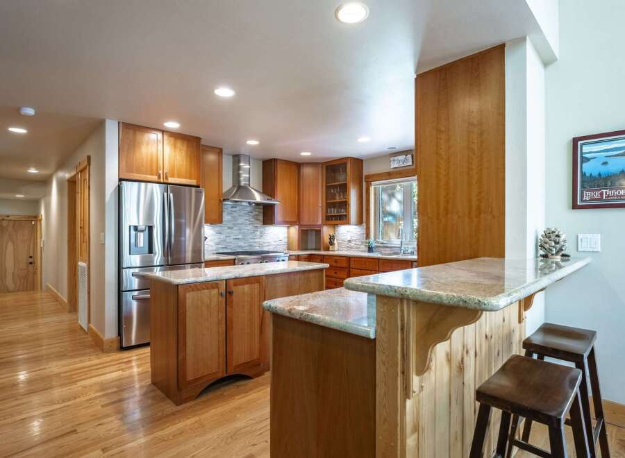 Discover this stunning kitchen featuring warm cherry wood cabinetry and a spacious island perfect for meal prep and casual dining.