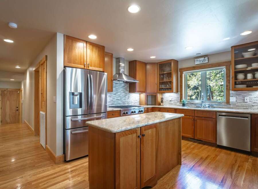 Experience the warmth of this inviting kitchen, featuring rich cherry wood cabinetry and a spacious granite-topped island perfect for meal prep and casual dining.