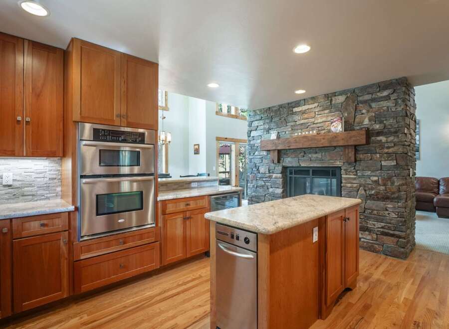 Experience luxury and comfort in this stunning kitchen, featuring a stacked stone fireplace as a captivating centerpiece.