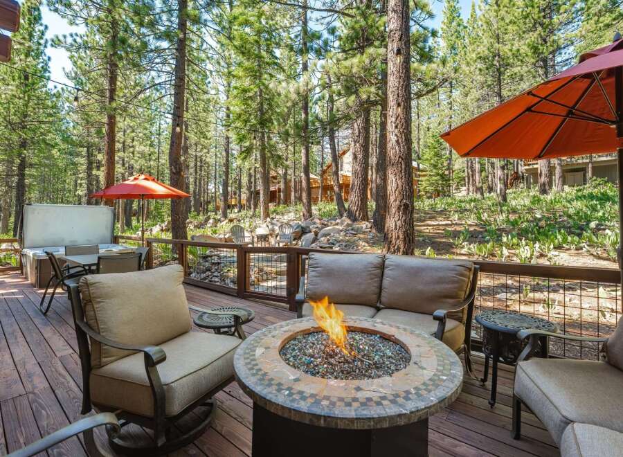 Experience outdoor living at its finest on this spacious deck, complete with a cozy fire pit and comfortable seating, perfect for gathering with loved ones.