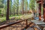 Enjoy the serene mountain lifestyle from this charming cabin deck, complete with a relaxing hot tub and outdoor seating area.