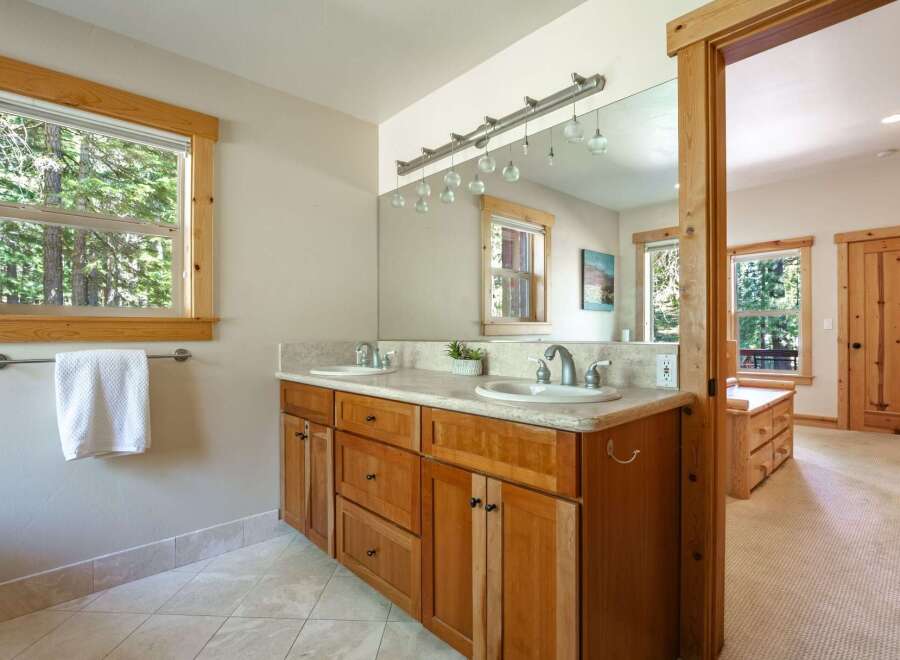 This spacious bathroom features a double vanity with ample counter space and warm wooden cabinetry.