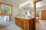 This spacious bathroom features a double vanity with ample counter space and warm wooden cabinetry.