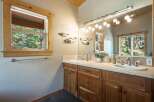 This charming bathroom features a double vanity with ample counter space and natural wood cabinetry.