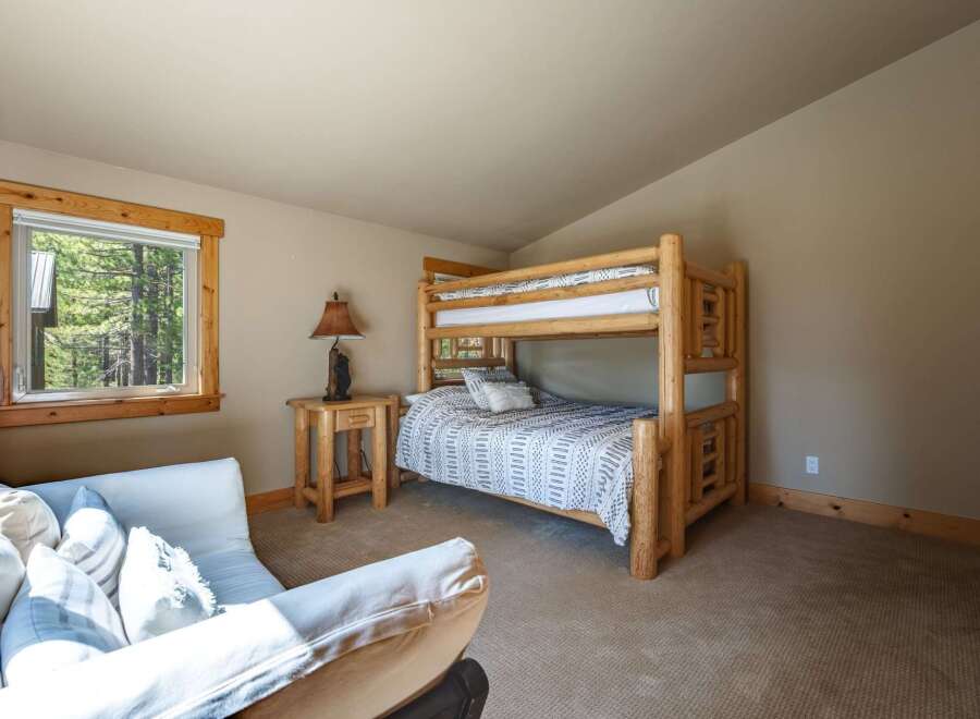 This charming bedroom features a rustic log bunk bed, perfect for accommodating guests or family.